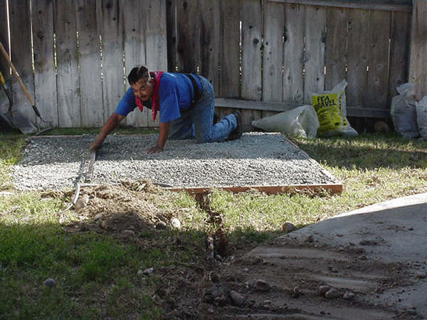 Diaz Service Crew Member finishing a pea gravel spa pad